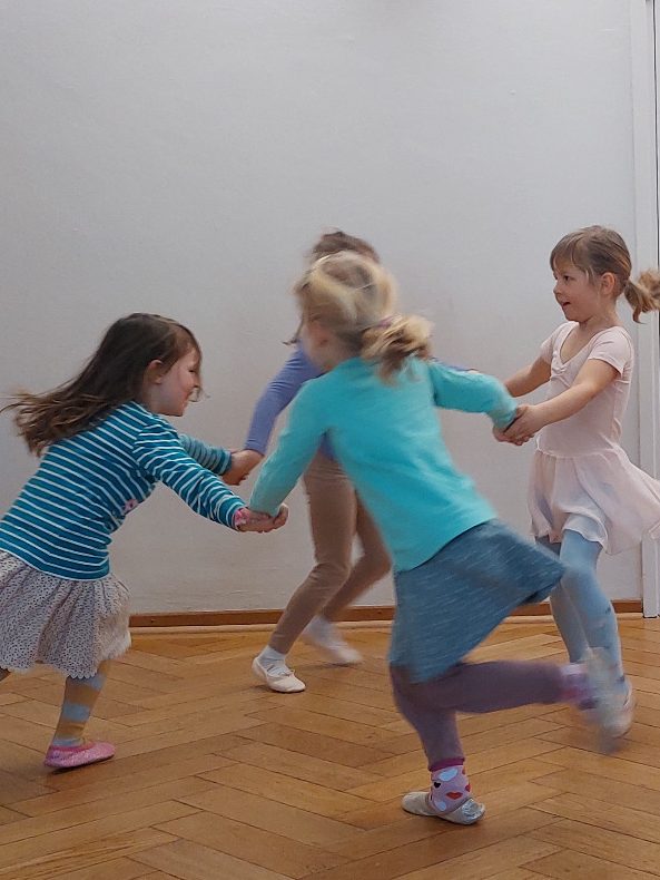 Kinder tanzen im Kreis